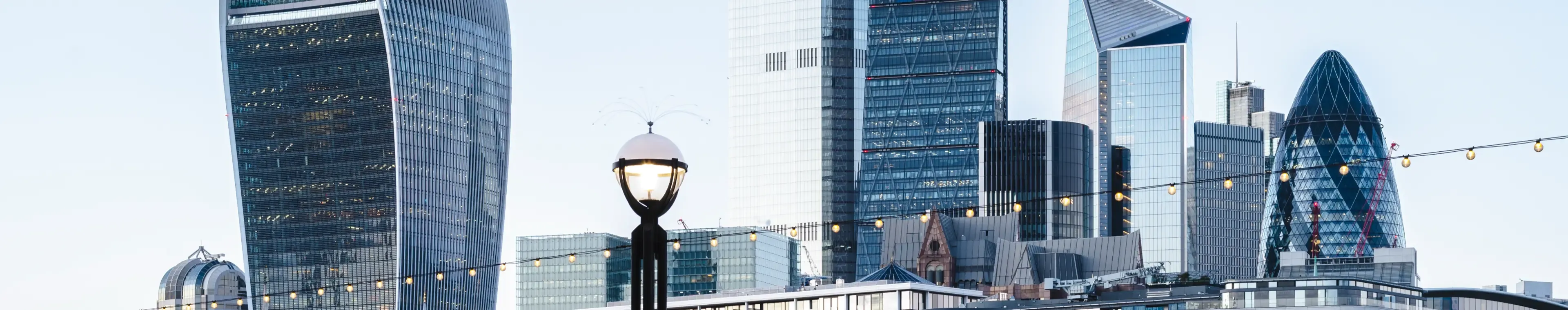 View towards the skyline of the City of London from the Thames Path at dusk