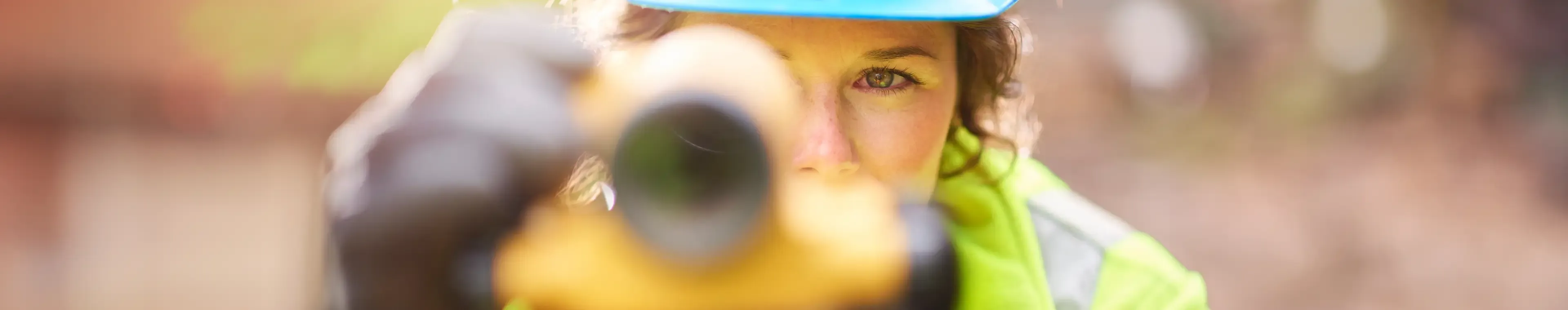 A young female surveyor checking her levels on site