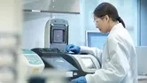 Scientist conducting the process of Polymerase chain reaction (PCR) to amplify DNA by using a thermocycler to create samples