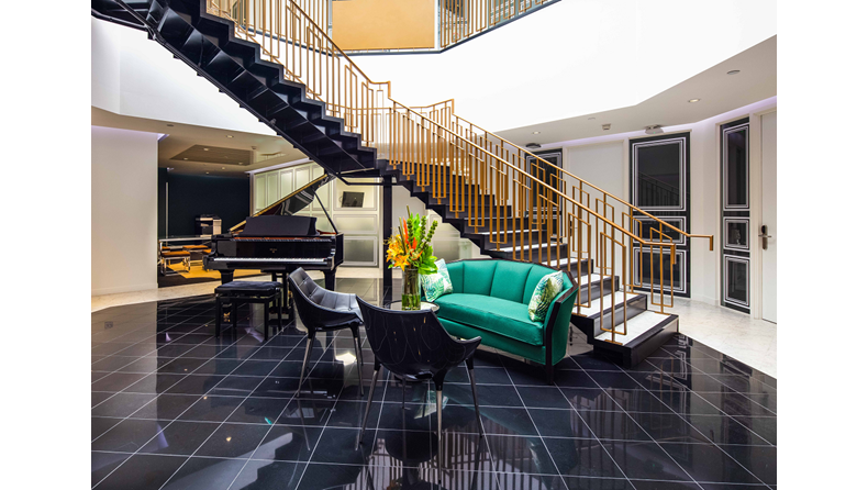 10 Brick Street's staircase, grand piano and plush green sofa